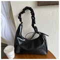Detail of black PU leather hobo bag with pleated cloud handle on wooden surface - Black