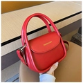 Detalle del bolso de cuero rojo con inscripción FASHION & BAG y asa redonda resistente - Rojo