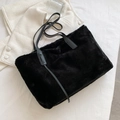 Elegante borsa tote nera in pelliccia sintetica con spalline in pelle su base bianca - Nero