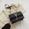 Elegant black quilted leather crossbody bag with gold V-shaped logo and chain tassel - Black