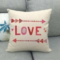 Dettaglio federa in lino con scritta LOVE e cuore su un divano grigio moderno - Design Lettera LOVE (1)
