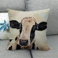Detailed view of the linen throw pillow case featuring a realistic cow portrait on a sofa - Off-white Cow Front Portrait