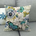 Dettaglio della federa in lino con motivi floreali e farfalle su un divano grigio - Viola del Pensiero Viola Farfalla Blu / 45x45cm