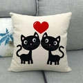 Detailaufnahme von Leinenkissenbezug mit schwarzen Katzen und rotem Herz auf Sofa - Symmetrisches Cartoon Katzenherz (7)