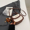Chic two-tone brown and white saddle bag with plush charm and gold metallic accent - With Pendant / Off-white