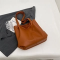 Bolso tote grande marrón caramelo con textura de lichi sobre blazer gris - Marrón