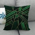 Close-up of abstract geometric patterns on a linen pillowcase atop a grey fabric sofa - Emerald Green Gold Marble Geometric