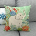 Close-up of linen cushion cover with white elephant and floral print on a gray sofa - White Elephant Style (11)