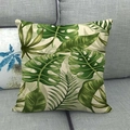 Détail de la housse de coussin en lin avec motifs de feuilles tropicales sur un canapé - 45x45 cm / Feuilles Tropicales Vertes (2)