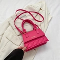Borsa a tracolla rosa acceso con trama a rombi e manico in un ambiente lifestyle - rosa acceso