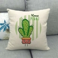 Detail of linen pillowcase with green cartoon cactus print on a grey fabric sofa - Green Cartoon Cactus Face (18)