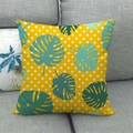 Detailansicht des tropischen Monstera-Leinenkissenbezugs auf einem grauen Sofa - 45x45 cm / Gelbe Monstera Punkte