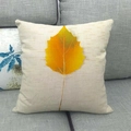 Detail of linen cushion cover featuring a golden autumn leaf print on a grey fabric sofa - Golden Yellow Autumn Leaf (7)