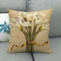 Detail view of linen pillow cover with white calla lily print on a dark gray sofa - Vintage Beige with White Calla Lily (10)