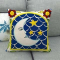 Close-up of linen pillow cover with yellow moon and folk art pattern on gray sofa - Moon & Star Pattern