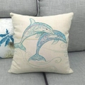 Housse de coussin en lin crème avec dauphins bleus aquarelle sur un canapé - Style Deux Dauphins Bleus (10) / 45x45 cm