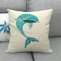 Housse de coussin en lin avec motif dauphin aquarelle posée sur un canapé gris - Style Dauphin Bleu Cyan (11) / 45x45 cm