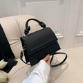 Minimalist black matte leather handbag with unique knotted handle and gold metal rings - Black