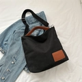 Bolso tote de lona negra minimalista con asas de cuero marrón y correa ajustable de tela - Negro