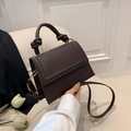 Deep chocolate brown crossbody bag with unique knot handle and flap closure detail - Brown