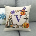 Dettaglio del copricuscino Halloween con lettera V e zucche su un divano grigio - Lettera V Viola (22) / 45x45cm