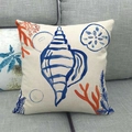 Funda de cojín de lino con caracola azul pintada a mano y coral sobre sofá gris - 45x45 cm / Estilo Caracola (3)