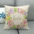 Fodera per cuscino in lino con ghirlanda di succulente e scritta Love su divano grigio - Cerchio di Piante Grasse Love