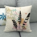 Cute bird feather linen pillow cover with never look back text on a grey sofa - Triple Feathers With Text (1)