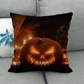 Halloween decorative throw pillow featuring a glowing Jack-o'-lantern on a grey sofa - Single Glowing Pumpkin