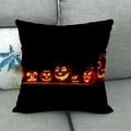 Detail of Halloween linen pillowcase featuring glowing pumpkins on a grey sofa - Six Pumpkin Faces Black Base
