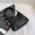 Borsa tote a mezzaluna nera minimalista in tessuto opaco con blazer e rivista - Nero