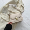 Chic cream white leather crossbody bag featuring unique rabbit ear shaped metal buckle - White