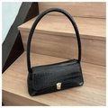 Detalle del bolso de hombro negro con textura de cocodrilo y hebilla dorada en madera - Negro