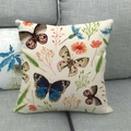 Leinen-Kissenbezug mit buntem Schmetterlings- und Pflanzenmuster auf einem grauen Sofa - Off-White Handgemalter Schmetterling Blumenstil (24) / 45x45 cm
