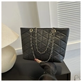 Dettaglio borsa tote nera trapuntata con cuciture geometriche e catena in metallo dorato - Nero