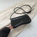 Borsa sottobraccio minimalista in pelle nera con logo oro su blazer beige - Nero