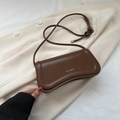 Borsa sottobraccio in pelle marrone con logo dorato su sfondo elegante blazer bianco - Marrone