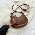 Brown faux leather crescent shoulder bag with matching mini pouch on white blazer - Brown