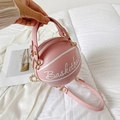 Pink basketball shaped chain handbag with white cursive lettering shown in hand - Pink