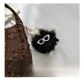 Dettaglio di un ciondolo in peluche nero con occhiali da sole su borsa a secchiello - Colore Casuale