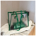 Close-up of translucent frosted PVC tote bag featuring colorful rhinestones and green leather trim - Green