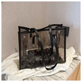 Detail of clear PVC tote bag featuring colorful rhinestone studs and black leather trim - Black