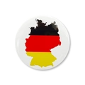 Close-up of a round tinplate badge featuring the German flag colors and country map contour - Germany Map Flag