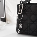 Detailansicht eines grauen Kristall-Taschenanhängers mit silbernem Metallclip an der Tasche - Unregelmäßiger Schild-Stil (0086) / Silber