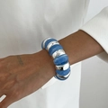Macro detail of sky blue resin and silver metal links on a wide chunky statement bracelet - Light Purple