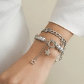 Bracciale multistrato argento con ciondoli a stella e perle grigie al polso della donna - Bracciale Bianco K (4751)