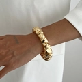 Detalle de brazalete ancho dorado con diseño de textura de lava irregular y brillo metálico - Estilo ondulado irregular (0125) / Dorado