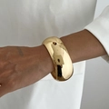 Primer plano de un brazalete ancho y grueso de oro con acabado de espejo pulido en muñeca - Estilo ancho liso (02591) / Dorado