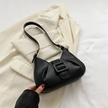 French style black pleated baguette bag with large buckle on a beige suit - Black