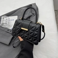 Classic black quilted handbag with golden hardware and top handle in a minimalist style - Black